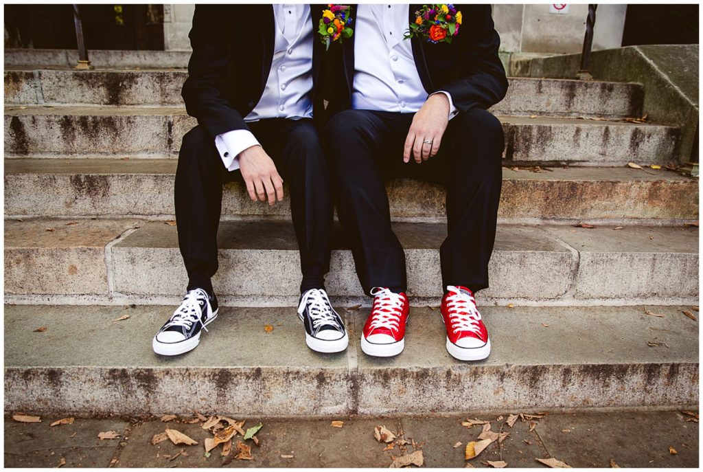 Couple sitting on the stairs of the Michigan Law Library with only their waists and converse shoes showing. Brian + Michaels Oz Themed Wedding