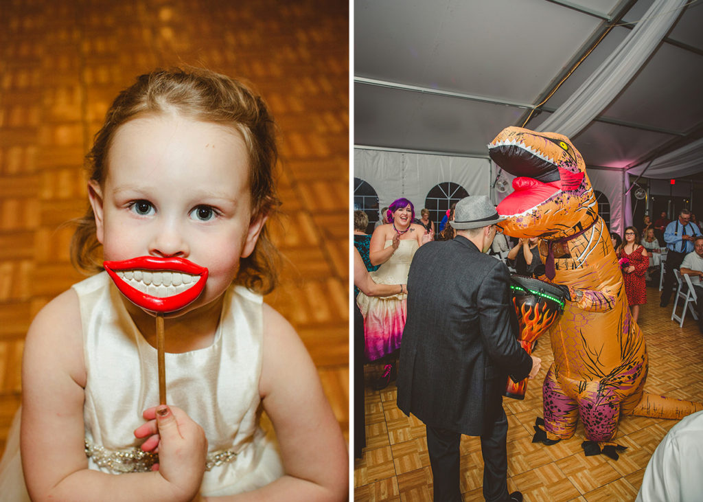 A flower girl at a wedding reception looking at the camera holding a photo booth smile on a stick prop in front of her mouth. A little boy dressed in a T-Rex costume dancing at a wedding reception at Waldenwoods Wedding Venue in Howell Michigan. Cut your guest list.