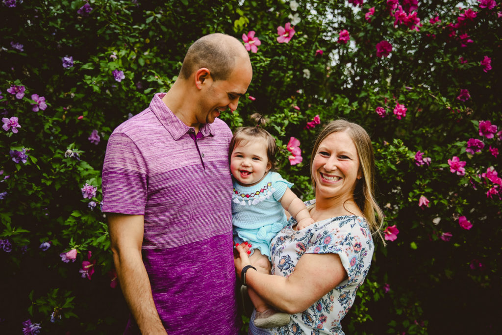 Family holding their little girl smiling at the camera. Milestone session planning guide.
