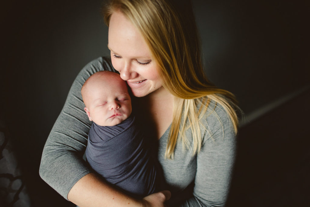 Mom holding her newborn baby. What to wear to your newborn session.