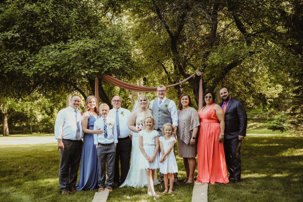 A large family photo at a couples wedding of everyone looking at the camera. Family photos on your wedding day. 