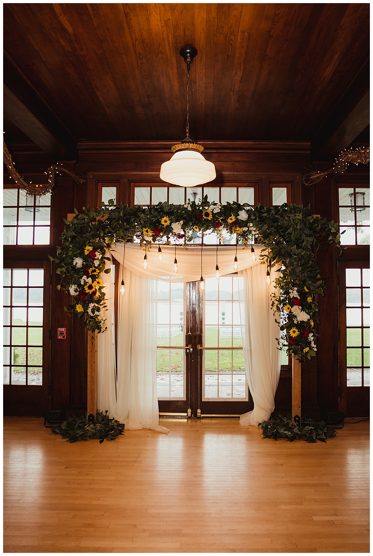 the wedding arch with white curtain and flowers
