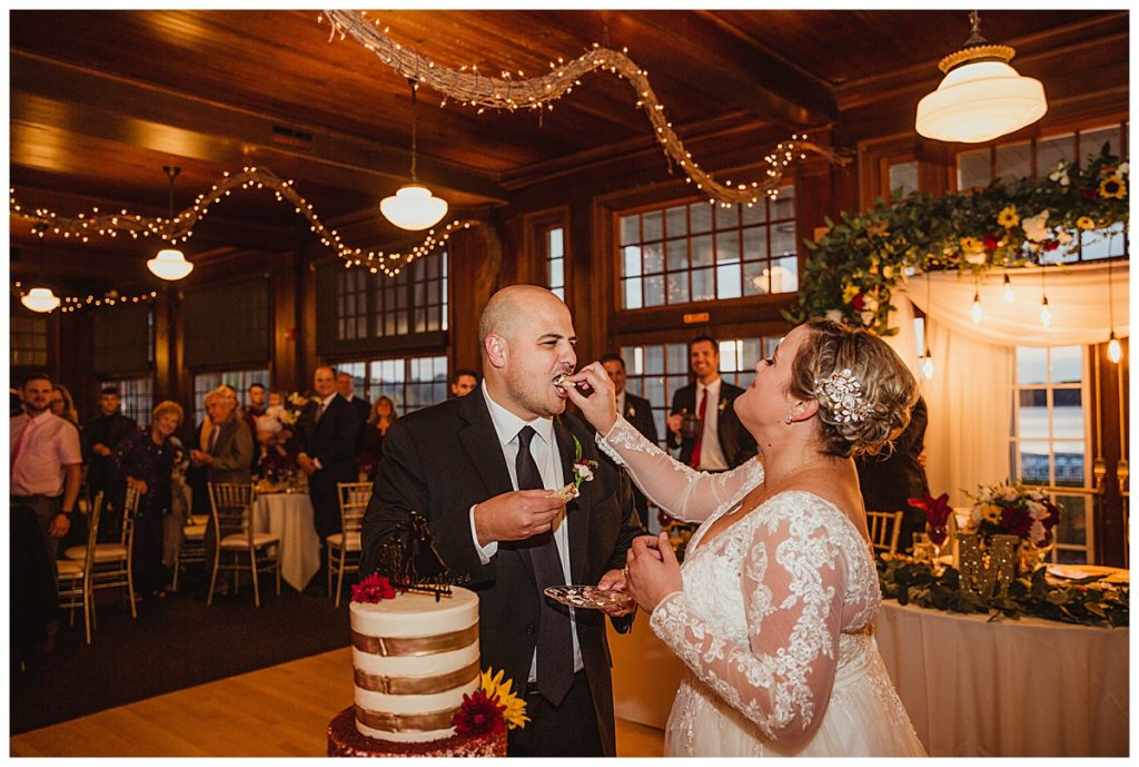 bride and groom feed each other wedding cake